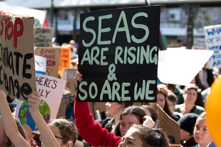 Student protesters from the March for Nature holding signs, one reading: "Seas are rising and so are we"