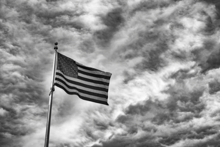Flag of the United States of America against a cloudy sky - black and white